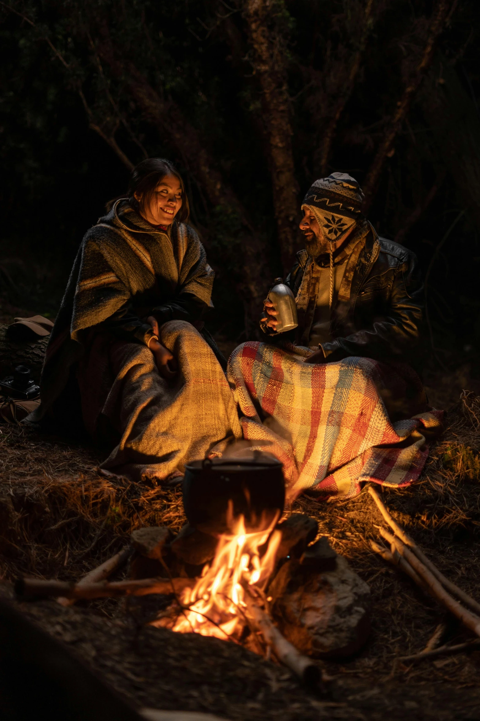 two native indian women sitting in front of the fire