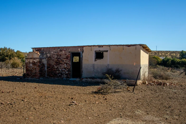 a small building made from bricks on the dirt