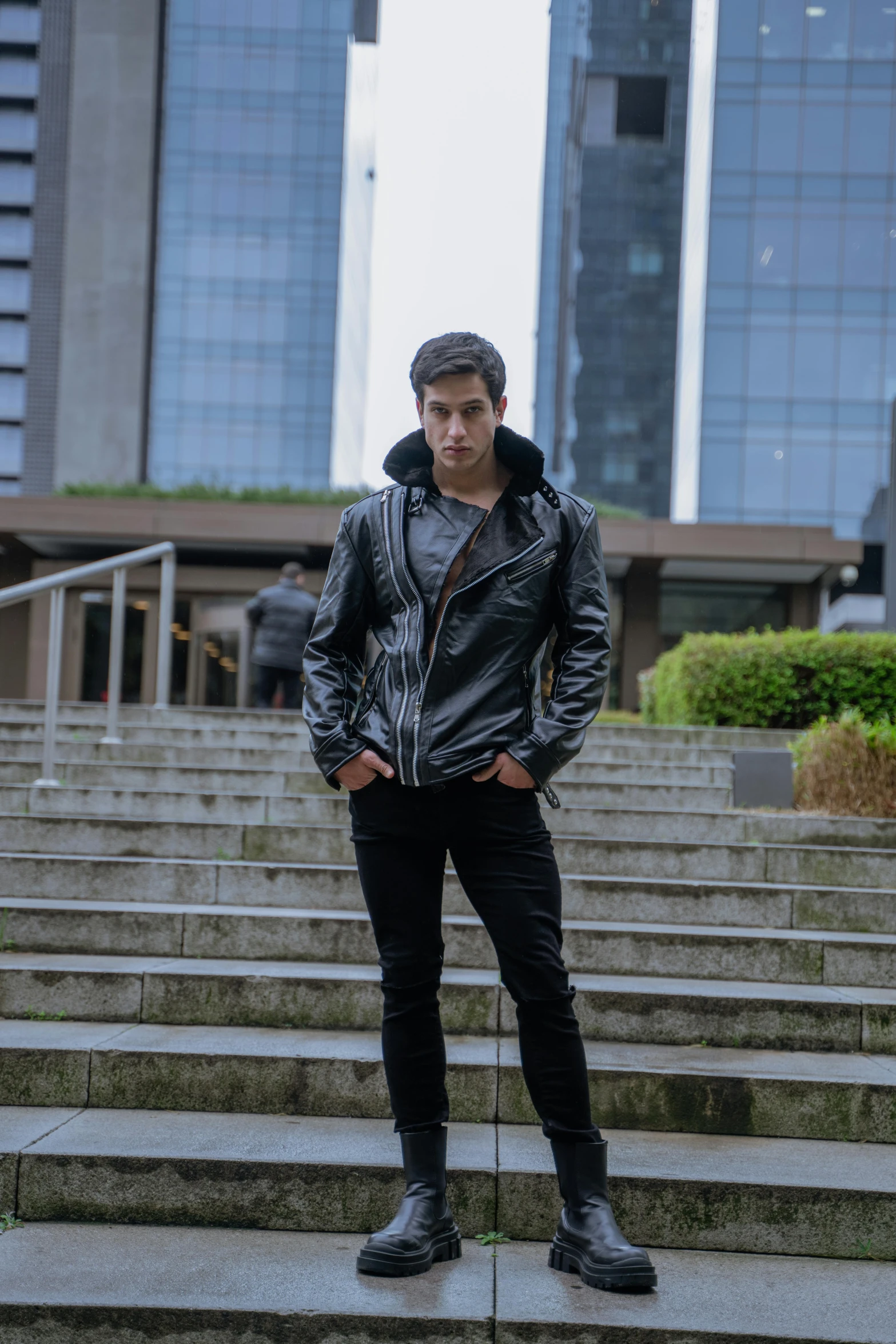 a man in a leather jacket on some stairs