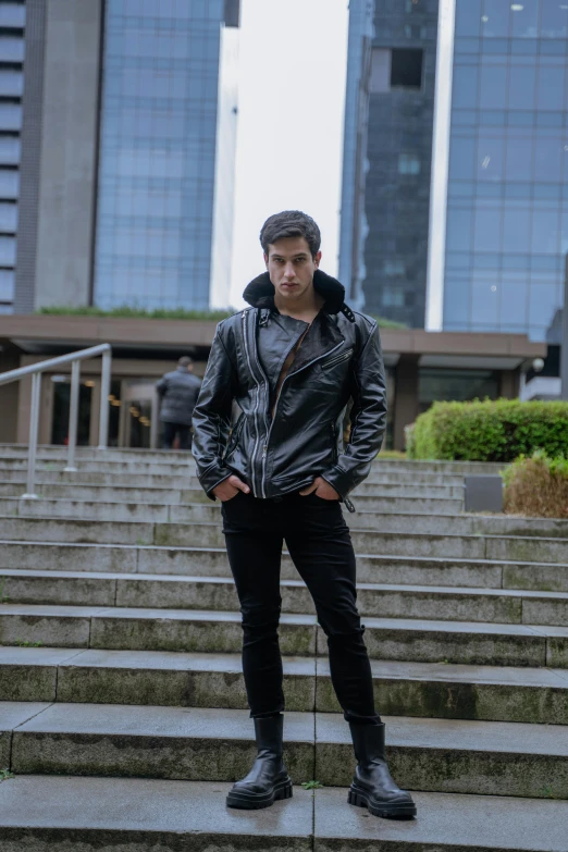 a man in a leather jacket on some stairs