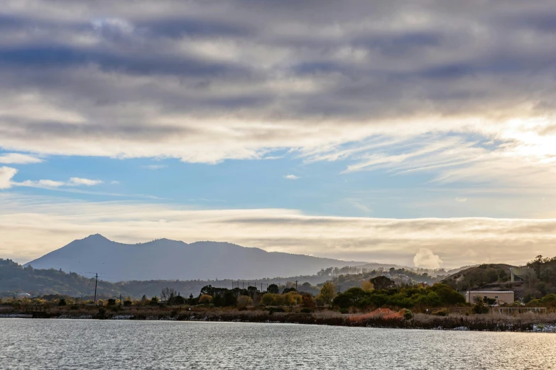 a boat floating on top of a lake under cloudy skies