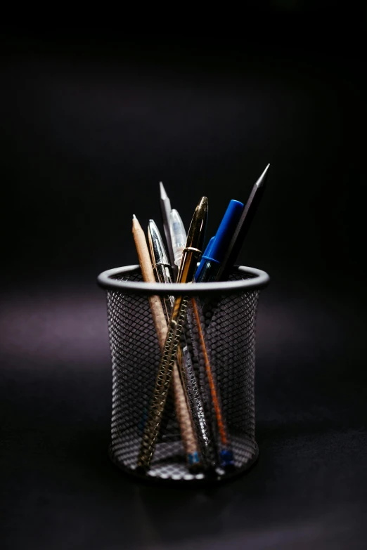 several pens and markers are sitting in a cup