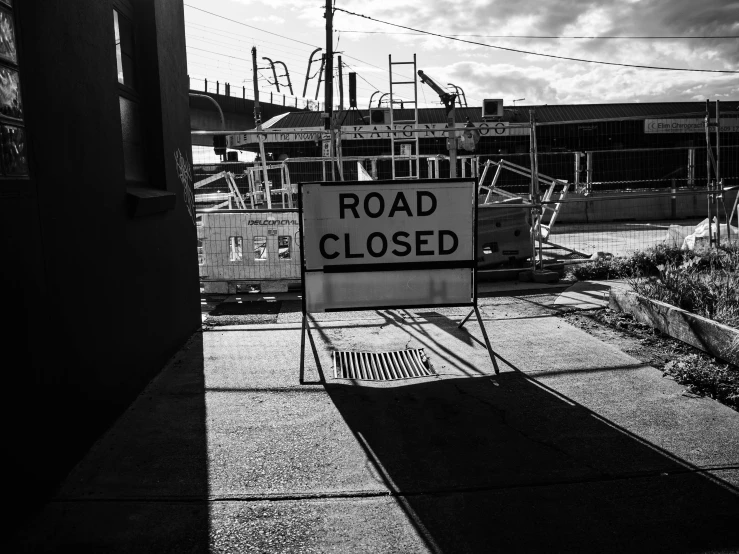 there is a road closed sign attached to the fence