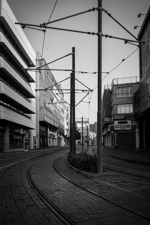 an empty railroad track lined with buildings and wires