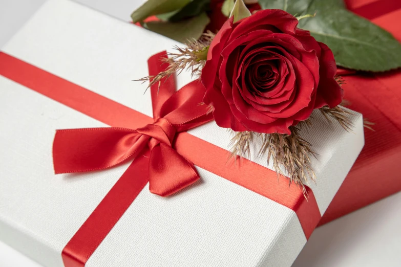 a single red rose is sitting next to a box