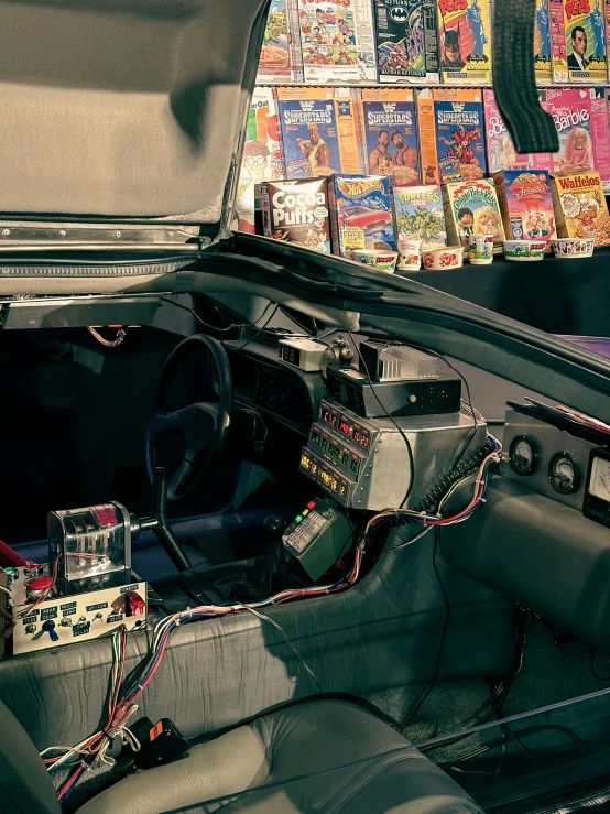 an abandoned car inside with colorful posters in the background