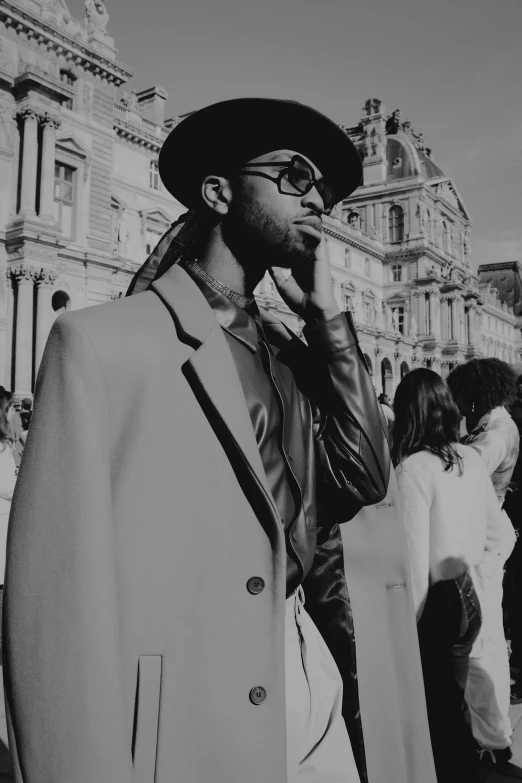 a man with glasses and a hat is talking on his phone