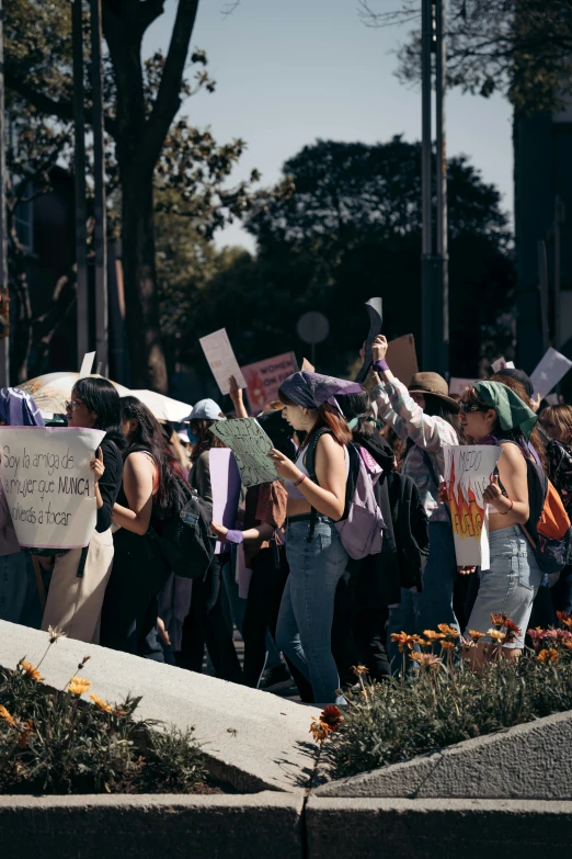 a crowd of people protesting with signs that read and sing