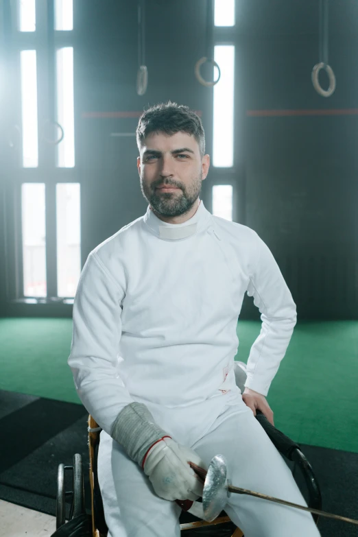 a man sitting in a wheel chair wearing white clothes