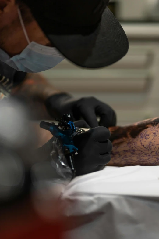 a tattoo artist working on an arm