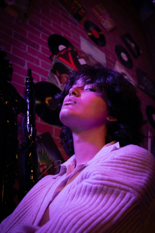 a woman in pink looking up with records on the wall