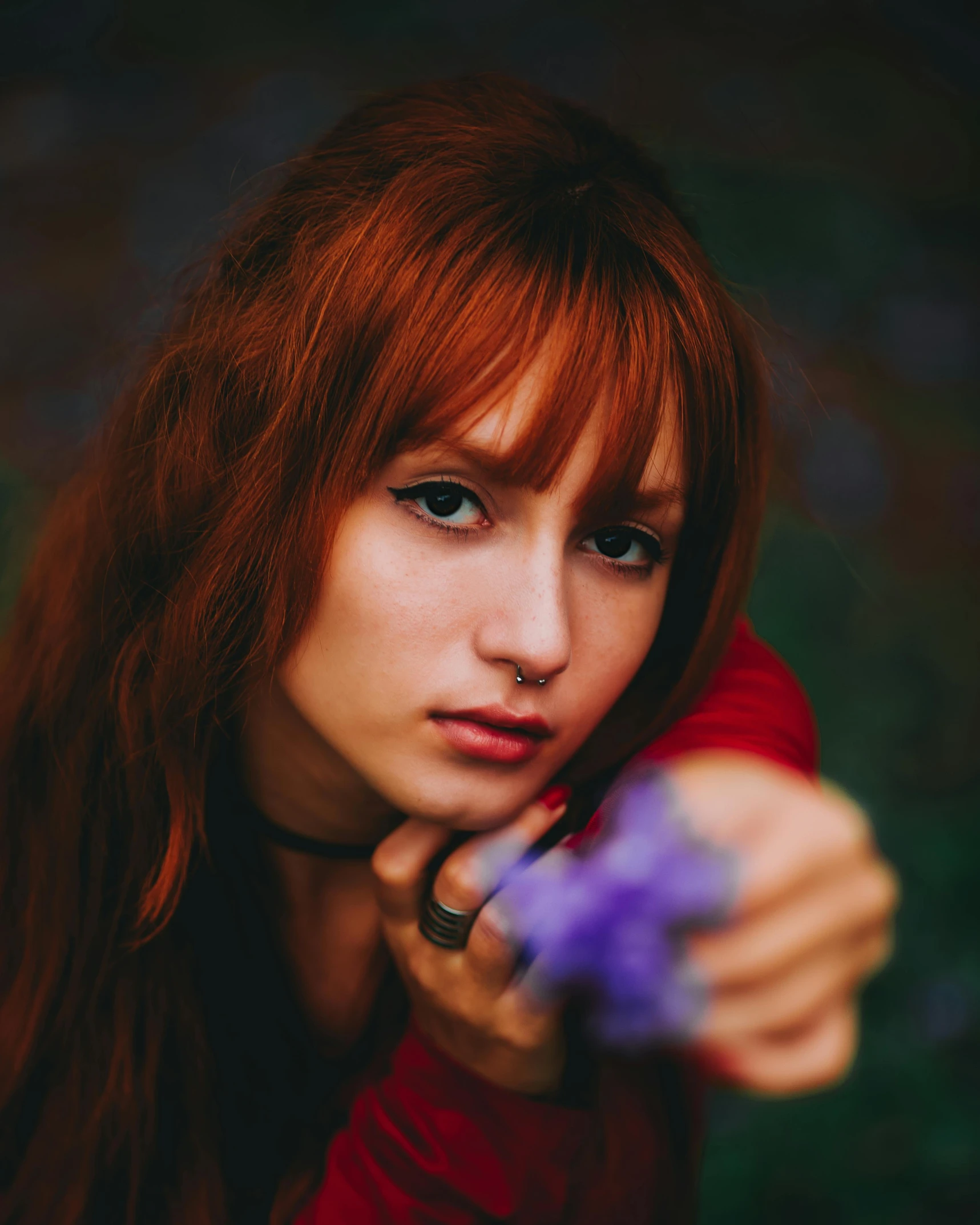 a woman with long red hair pointing the camera