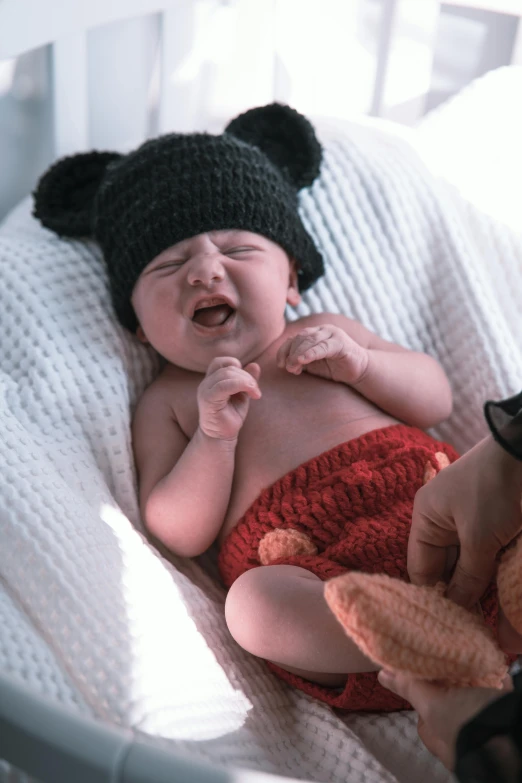 a newborn baby is wearing a mickey mouse outfit