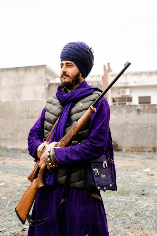 a man holding a rifle and a bag