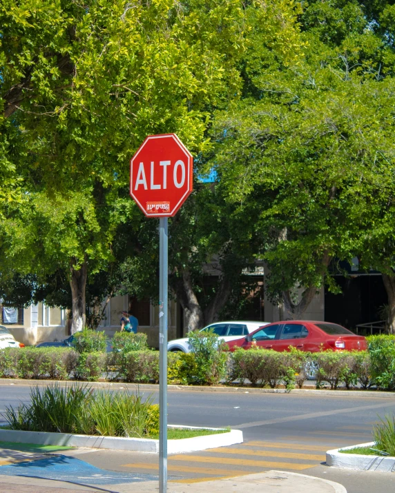 a red stop sign on the corner near the road