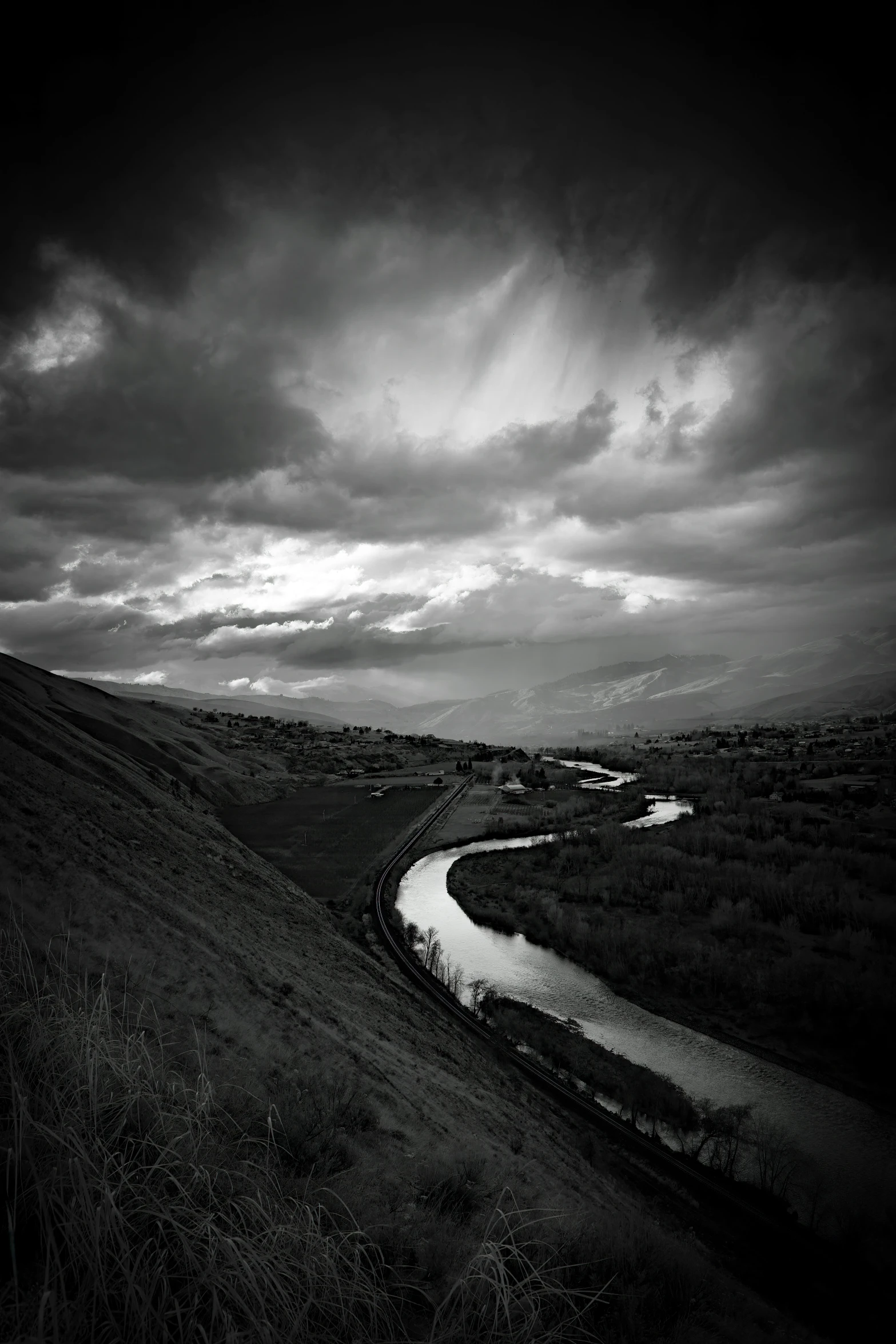 the black and white landscape has clouds above it