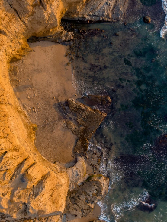 an aerial view of rocks and water on the beach