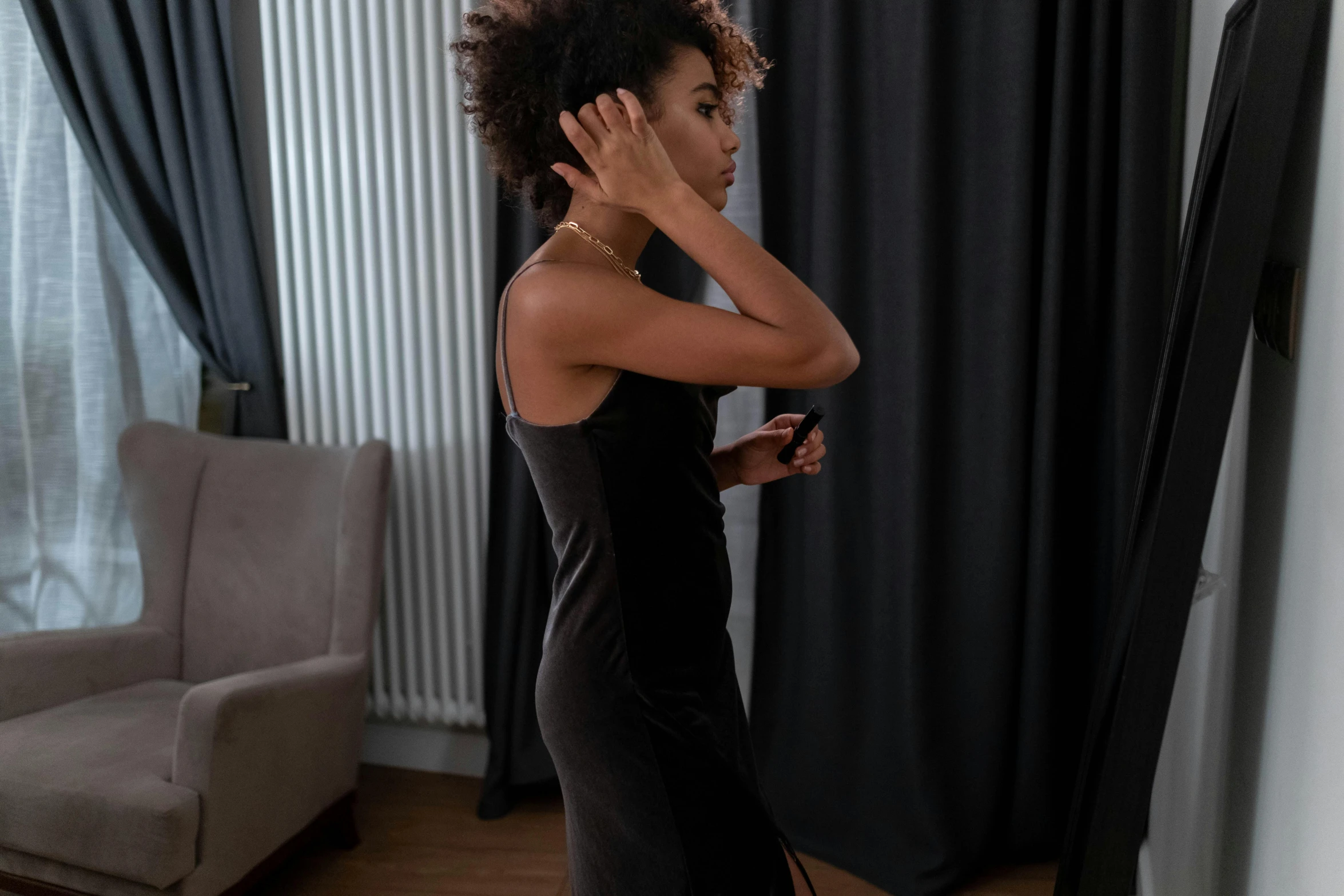 a young black woman is holding her hair in an up - side ponytail