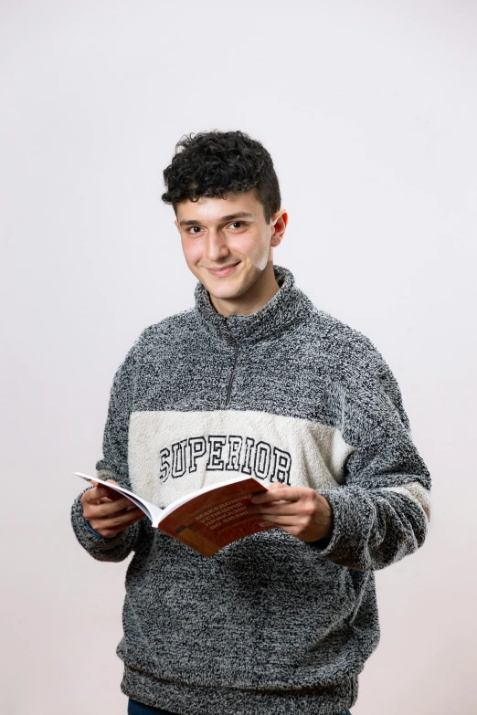 a young man holding up a book with the words suffer on it