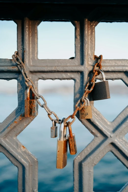 there is many padlocks attached to a fence with two keys