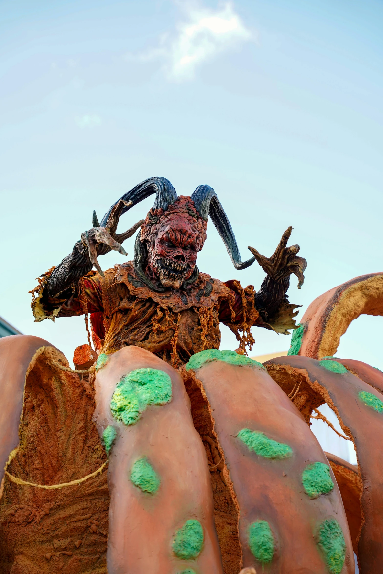 a close up of a statue of a creature with green moldy paint on it's face and arms