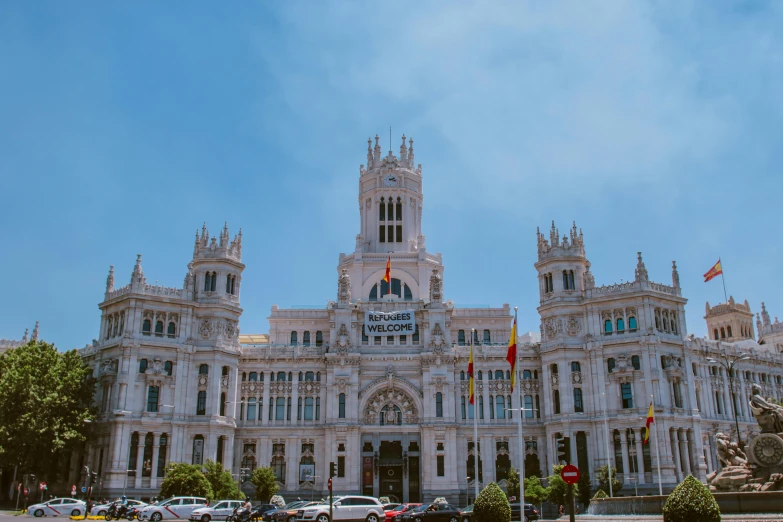 a very tall white building with flags and clock tower