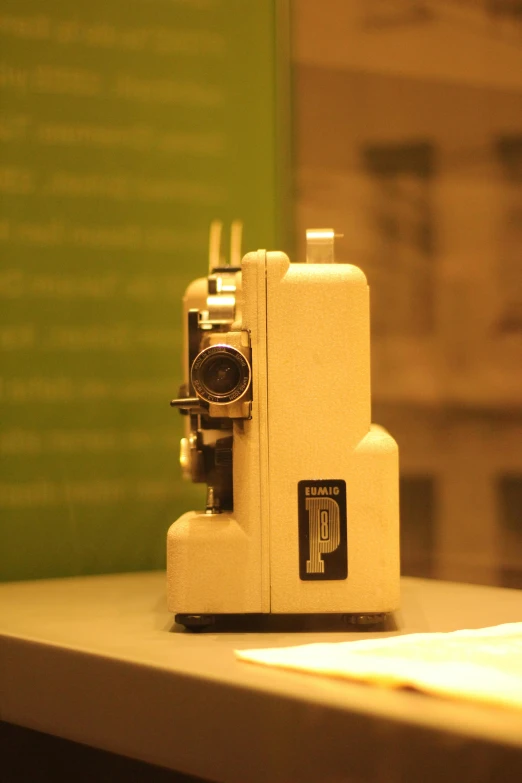 small sewing machine on table with green wall