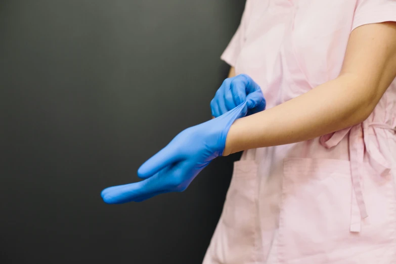 a woman holding soing blue with blue gloves on