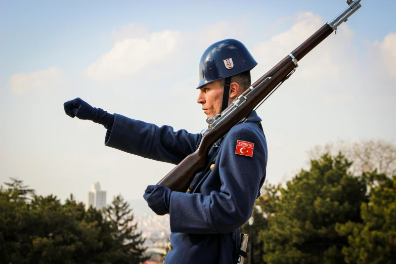 a man in uniform is holding a rifle