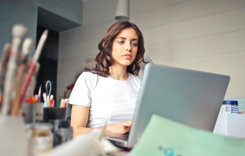 a  working on a laptop at her desk