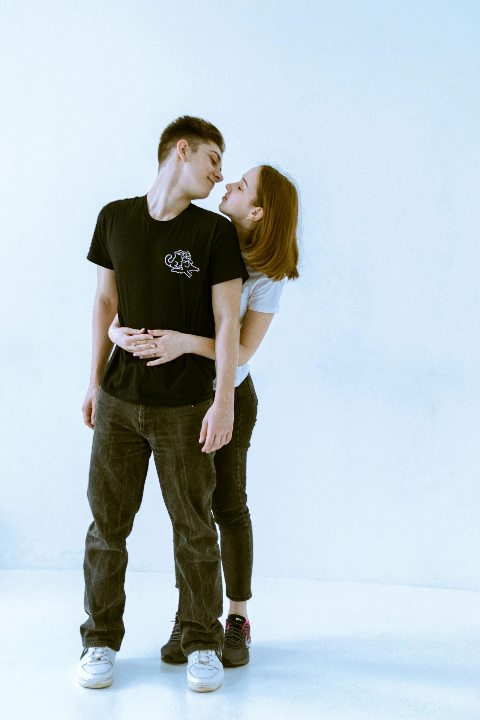 a man and woman standing close together with one man rubbing his face against the woman's chest