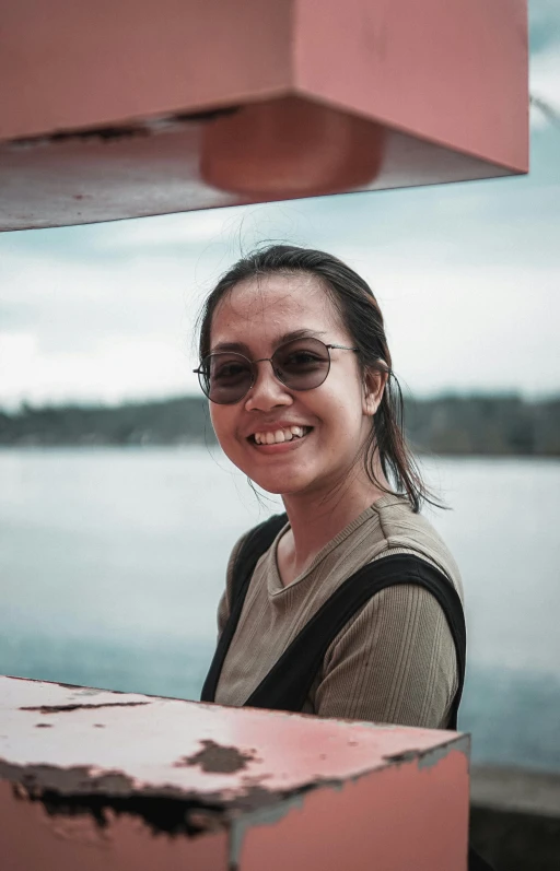 a woman in a shirt and sunglasses smiles at the camera