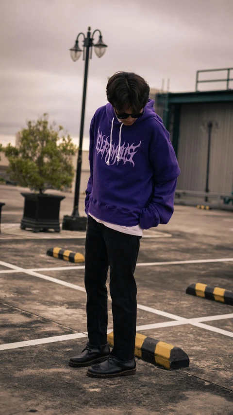 a man standing in a parking lot on his skateboard