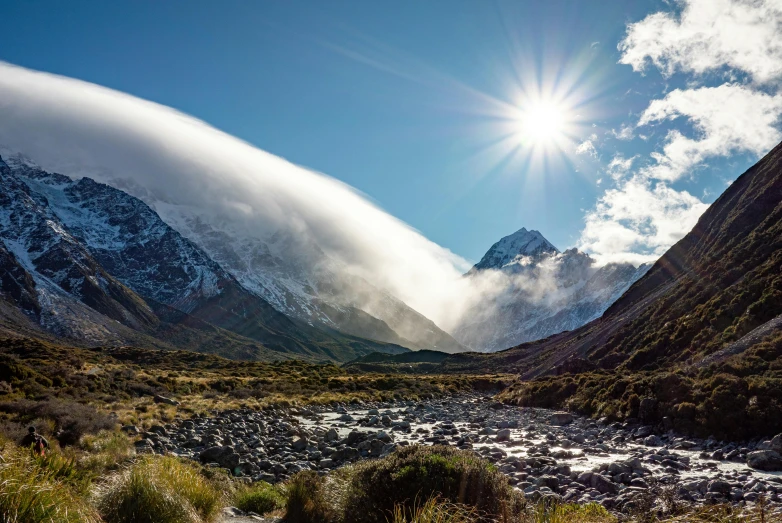 a river in a mountain range with mountains in the background