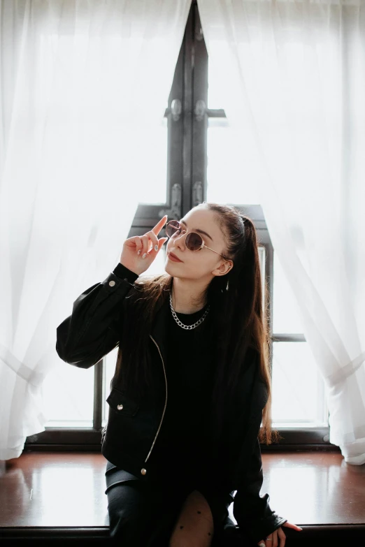 woman sitting on the floor holding sunglasses on top of her head