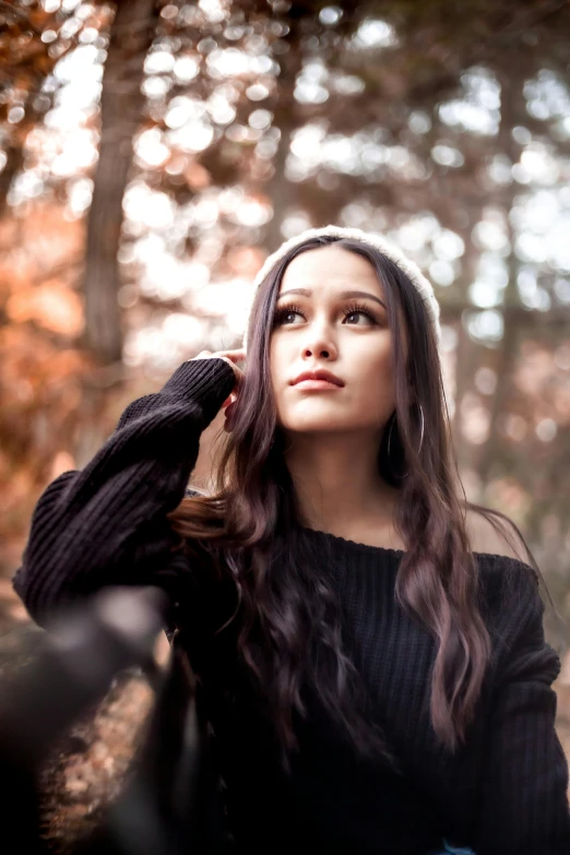 a woman is wearing long brown hair and has her arms near her head