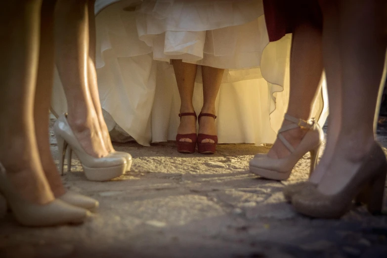 four ladies's legs, dressed in high heeled shoes