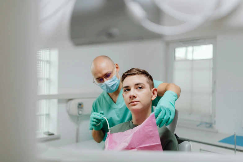 a man sitting in a chair getting a haircut