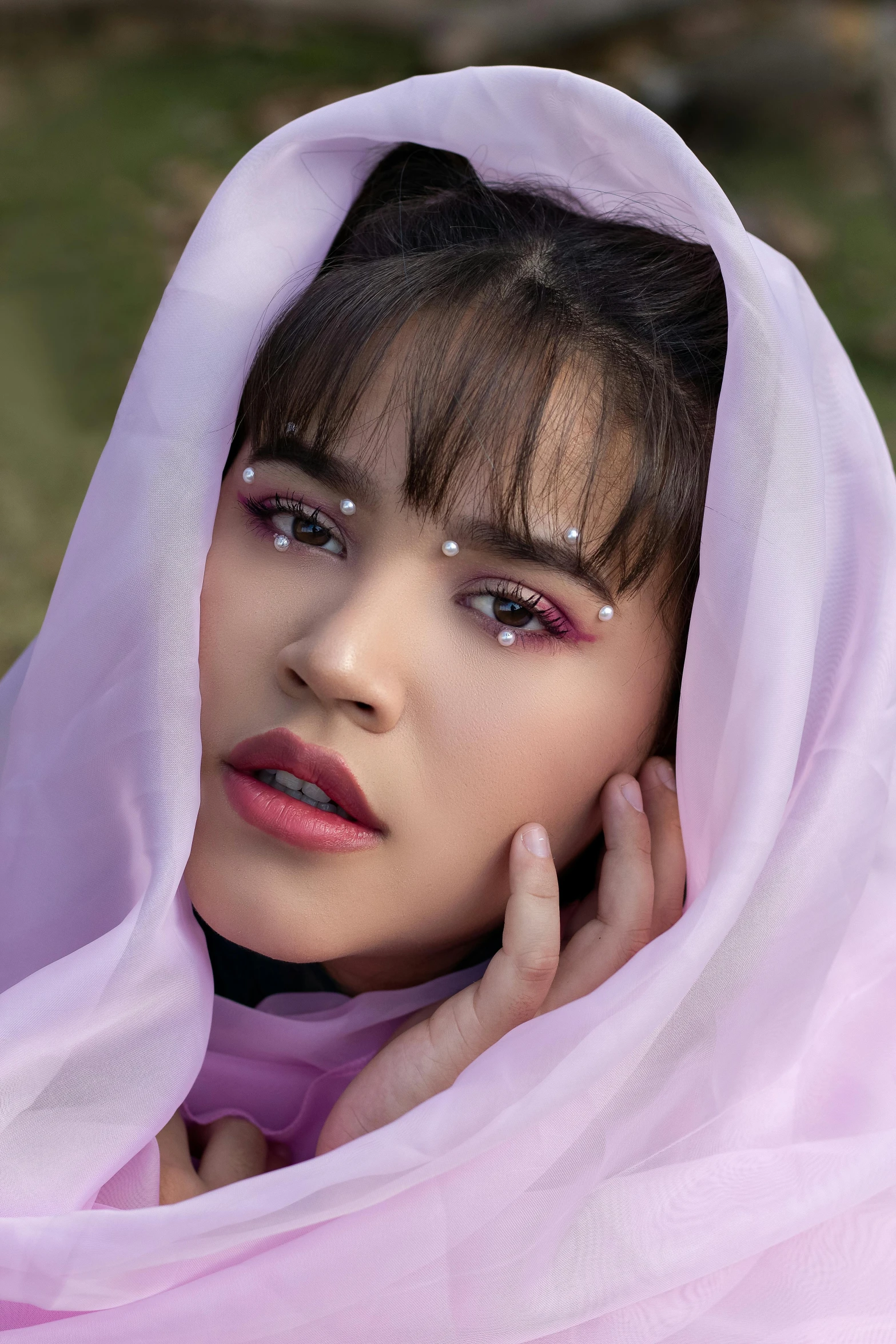 a woman wearing a pink scarf and looking out the window