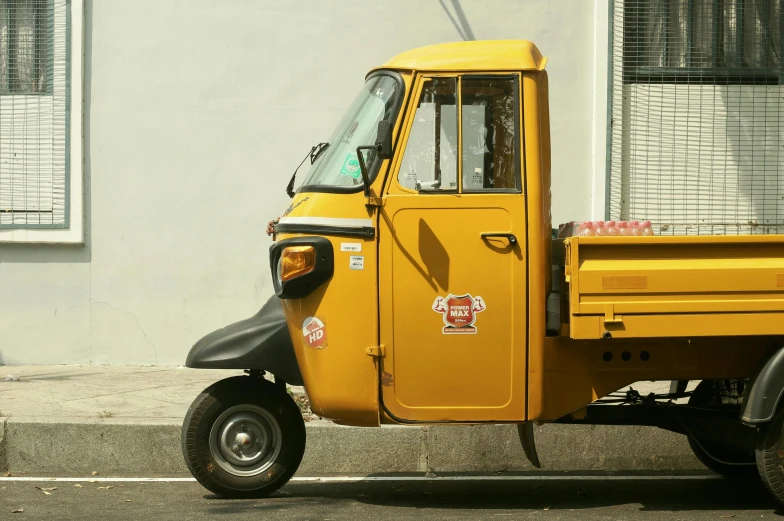 an older yellow utility truck parked on the side of a road