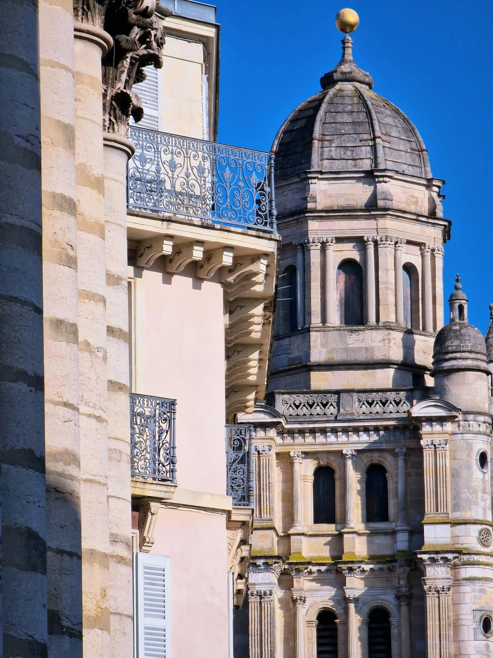 a large tower with a clock near a row of buildings