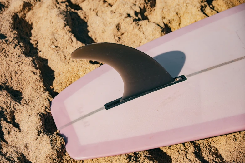 a surf board laying on the sand on the beach