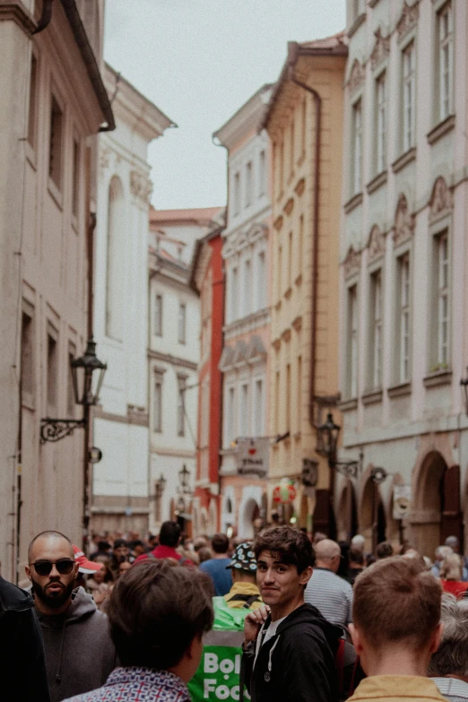 a group of people standing in a street next to buildings