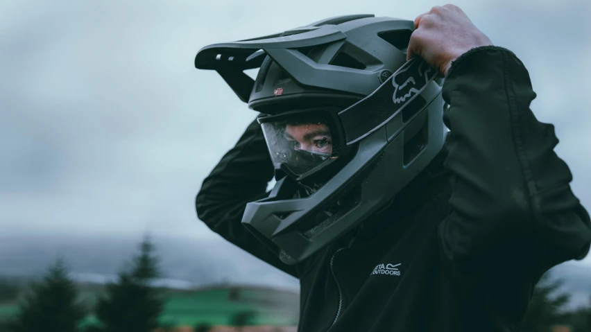 a person holding onto the top of their helmet