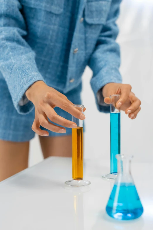 a woman is holding two test tubes on a white table