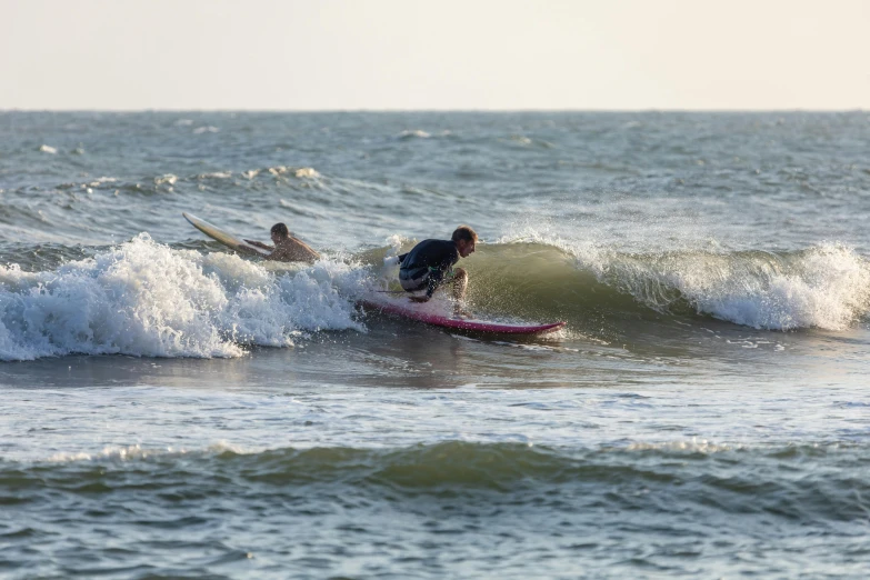 two people on their surfboards in the water