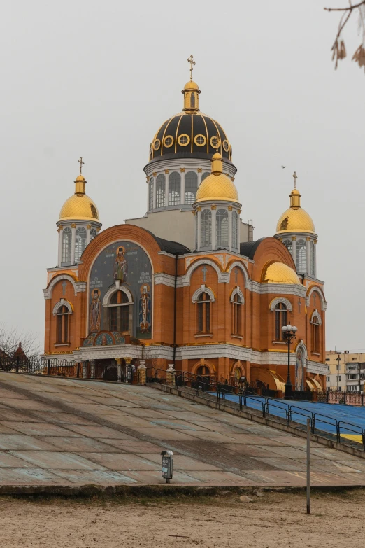 a large church on top of a hill next to a tree