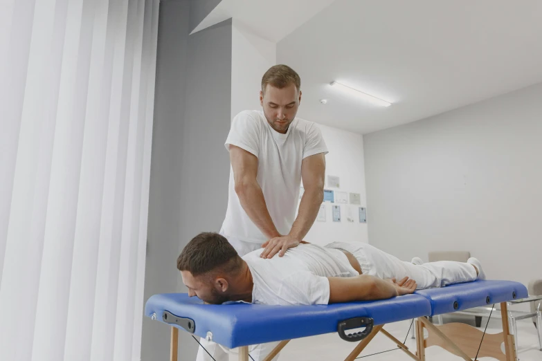 a man getting a physical massage from a man on a bed