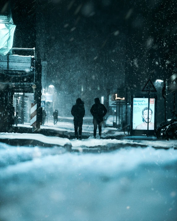 a couple of people walking across a snow covered road