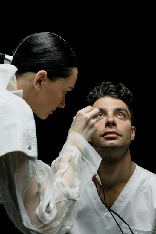 a woman in white getting ready for a performance with a man